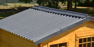 Abri de jardin en bois avec toiture en plaques bitumées ONDULINE EASYFIX Gris anthracite, faîtière et rives Onduline, dans un jardin