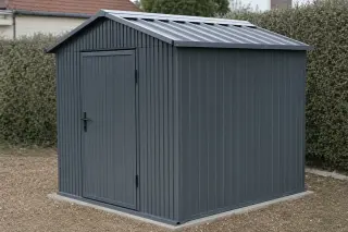 Abri de jardin en acier galvanisé anthracite, parois et toiture nervurées, dans un jardin