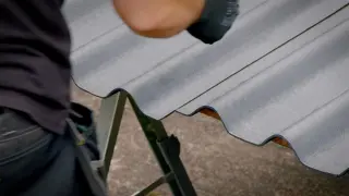 Mise en place d'une plaque ondulée bitumée ONDULINE EASYFIX® en rive de toiture d'abri de jardin, avant fixation en sommet d'onde