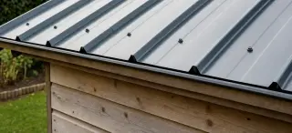 Toiture d'abri de jardin en plaque métallique profilée anthracite simple peau posée sur charpente bois avec vis à joint d'étanchéité