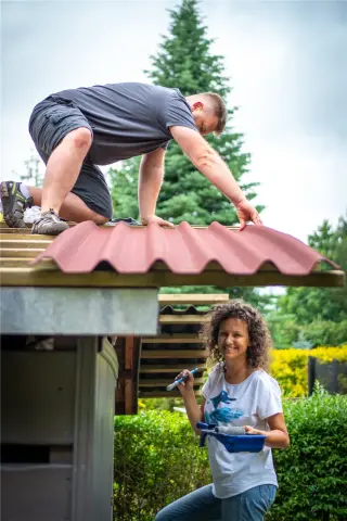 Toiture d'abri de jardin en plaques bitumées ondulées ONDULINE EASYFIX rouge posées sur voligeage, fixations en sommet d'onde, faîtière et rives assorties, débord de 7 cm à l'égout