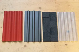 Quatre échantillons de couverture pour abri de jardin posés côte à côte : plaque bitumée ondulée ONDULINE EASYFIX rouge, plaque métallique profilée anthracite, bardeau bitumé et plaque polycarbonate translucide
