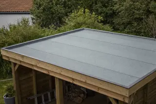 Toit plat d'un petit abri de jardin recouvert d'une membrane d'étanchéité ONDULINE BFX grise à surface aluminium, posée sur un support continu en panneaux jointifs