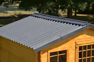 Toiture d'abri de jardin en plaques ONDULINE EASYFIX® anthracite : faîtière segmentée au sommet, rive le long du pignon et débord à l'égout