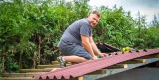 Pose d'une plaque ondulée bitumée ONDULINE EASYFIX rouge sur la charpente bois d'un abri de jardin, vis à rondelle d'étanchéité intégrée fixées en sommet d'onde et bande de rive blanche le long du pignon