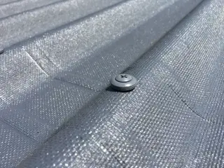 Gros plan d'une vis Onduline à rondelle d'étanchéité intégrée vissée en sommet d'onde sur une plaque ONDULINE EASYFIX® anthracite