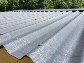 Toiture d'abri en plaques ONDULINE EASYFIX® anthracite : fixations en sommet d'onde et faîtière assortie posée par segments