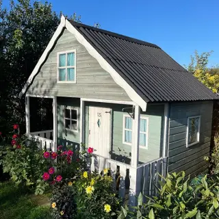 Petit abri de jardin en bois couvert en plaques bitumées ondulées ONDULINE® coloris anthracite, toiture deux pans avec débord de rive