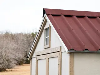 Pignon d'un abri de jardin couvert en ONDULINE EASYFIX® Rouge : rive assortie et débord de toit qui protègent la façade